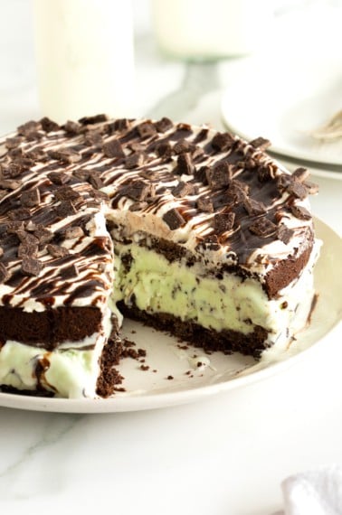 Mint chocolate chip ice cream sandwiched between chocolate cake layers and topped with whipped topping, chocolate sauce, and chopped Andes mints.